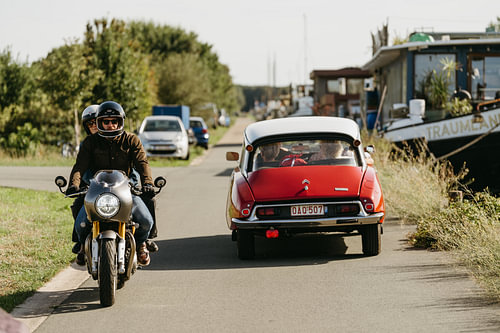 Vintage on the road – a Citroën DS and a classic motorbike by the water’s edge