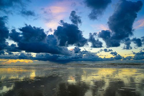 Zonsondergang op het strand van Texel met donkere wolken in de lucht