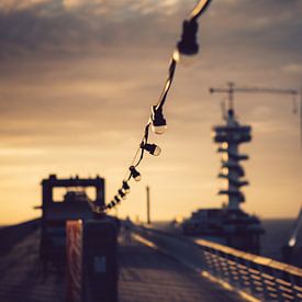 Opgehangen lampen op een pier tijdens zonsondergang van Christopher A. Dominic