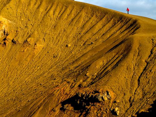 Lopen over de rand van de vulkaankrater van Krafla, IJsland