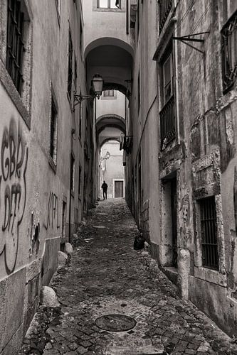 Monochrome image of a man walking through Lisbon's narrow starts. Wout Kok One2expose