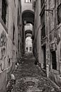 Image monochrome d'un homme marchant dans les rues étroites de Lisbonne. Wout Kok One2expose par Wout Kok Aperçu
