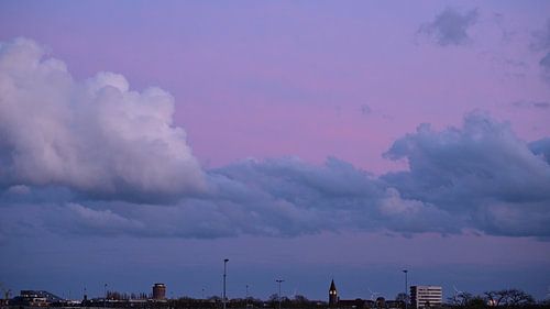 The city outskirts beneath pastel-coloured clouds