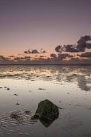 Een eenzame basaltblok op het Wad bij zonsondergang