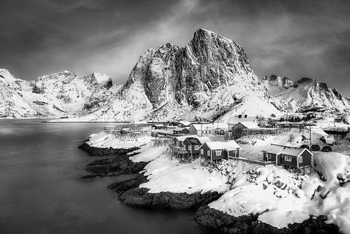 Winterlandschap met vissershuisjes aan de fjord in Noorwegen in zwart-wit.