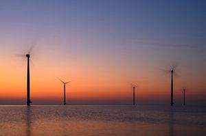 Windturbinen in einem Offshore-Windpark bei Sonnenuntergang