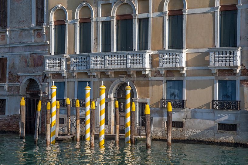 Alte Gebäude mit gelben Pfählen am Kanal in der Altstadt von Venedig, Italien von Joost Adriaanse