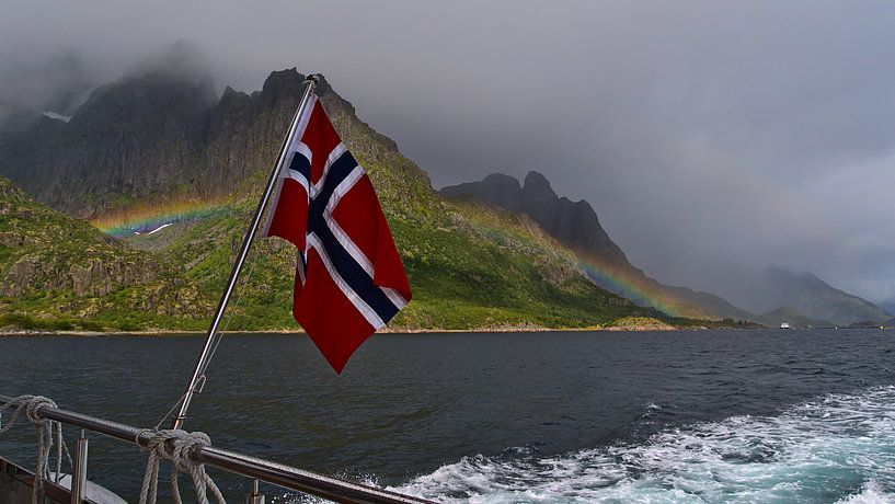 Noorse vlag op de achtersteven van een boot met regenboog en bergen van Timon Schneider