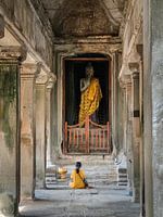 Woman praying to Buddha in Angkor Wat, Cambodia