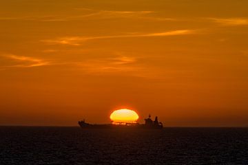 Zonsondergang met wolken en schip oranje zwart van Peter Cornelissen