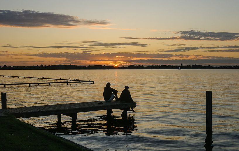 Coucher de soleil avec des gens sur la jetée des lacs de Loosdrecht par Martin Stevens