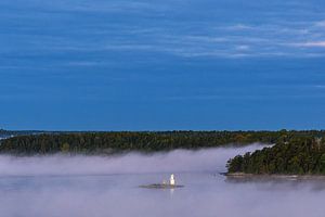 Inseln im Schärengarten mit Nebel und Leuchtfeuer vor Stockholm