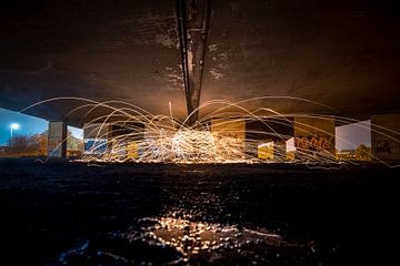 Lightpainting met vuurvonken onder viaduct