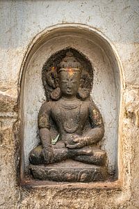 Boeddha beeld in een nis van een witte muur van een tempel in Nepal