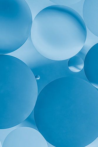 Ronde oliedruppels op water, verschillende blauw tinten