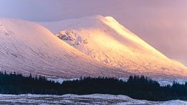 Besneeuwde bergtoppen bij zonsondergang in Glencoe. van Sonny Vermeer