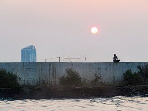 Junge an der Mauer bei Sonnenuntergang im alten Hafen von Jakarta, Indonesien