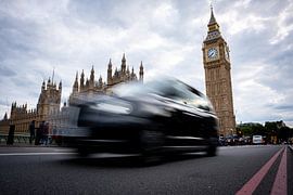 A London black cab with motion blur in front of the Palace of Westminster and Big Ben, London by René Wiegmink