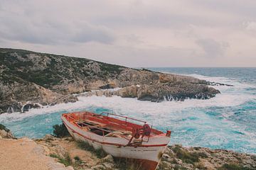 Abandoned boat on the cliffs of a rough sea in Zakynthos, Greece. by Lizet Wesselman