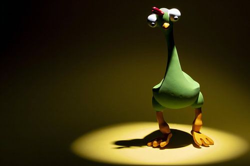 Grünes Spielzeug-Huhn mit großen Augen