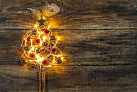 De vorm van de kerstboom met versieringen en warm licht op houten achtergrond van Alex Winter thumbnail
