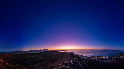 Het blauwe uur boven de kust – Panorama vanaf de berg op de zee en het vulkaanlandschap