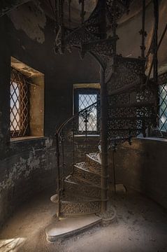 Een gietijzeren trap in een verlaten kasteel