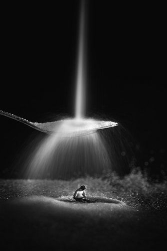 Miniature people: The sugar falls on the spoon while the man concentrates on reading his newspaper