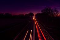 Beautiful glow in the sky with light trails on the road by Rob Baken thumbnail