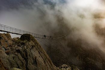 Steel suspension bridge in Switzerland with a beautiful but threatening sky