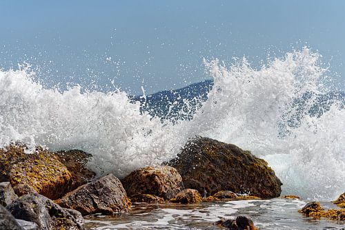 Strong surf over stones in sunlight