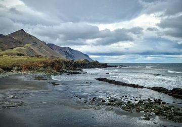 Zwart strand met bergen en rotsen in IJsland