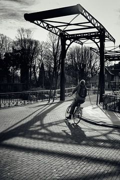 Straatfotografie in Utrecht. De fietser op de Muntsluisbrug. van André Blom Fotografie Utrecht