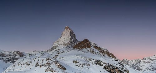 Schneebedecktes Matterhorn im Winter bei Sonnenaufgang in der Dämmerung.