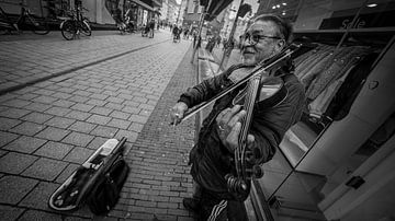 Straatmuziekkant in lege straat van JD