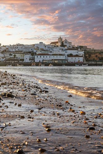 Zandstrand in de ochtend met uitzicht op het historische centrum van Ferragudo, Portimão, Algarve, Portugal