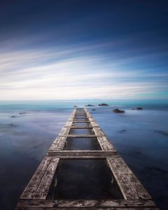 Hölzerne Seebrücke in einem blauen Meer. Livorno, Langzeitbelichtung