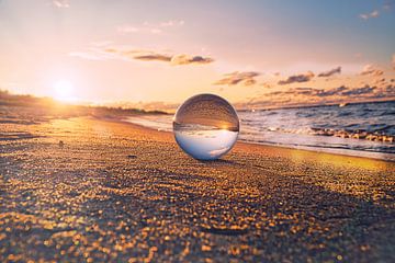 Glazen bol op het strand van Zingst, bij zonsondergang. De zon en de Baltische Zee worden weerspiege van Martin Köbsch
