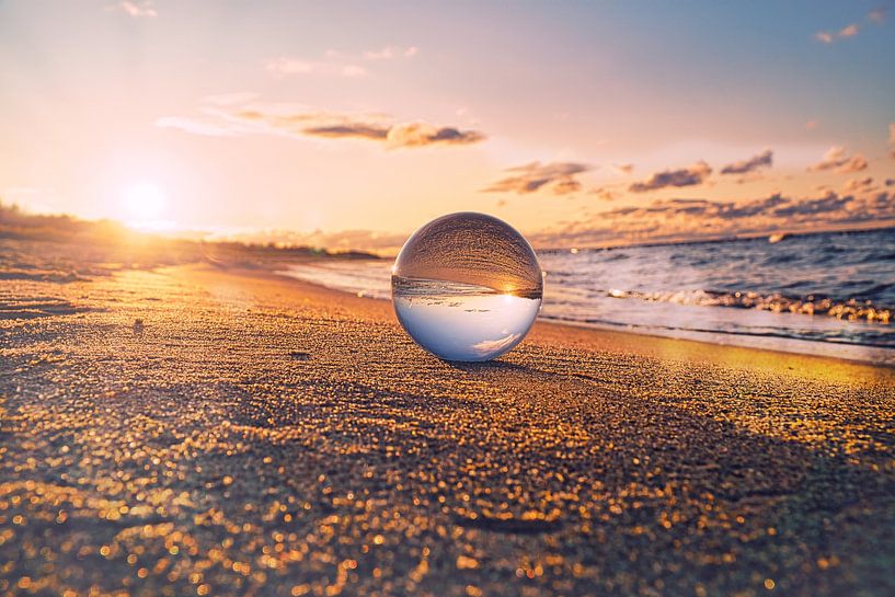 Glass sphere on the beach of Zingst, at sunset. The sun and the Baltic Sea are reflected in the sphe by Martin Köbsch