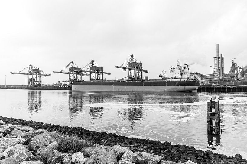 Een vrachtschip ligt zwaar en stil afgemeerd van scheepskijkerhavenfotografie