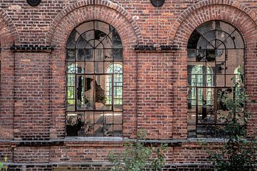 kapotte ramen in een oude fabriekshal in lodz polen van Eric van Nieuwland