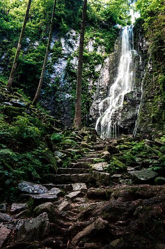De mooie Burgbach waterval midden in het bos met stenen trappen