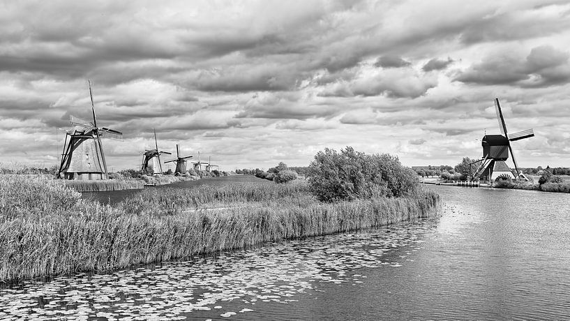 Windmolens in de buurt van een kanaal met dramatische wolken van Tony Vingerhoets