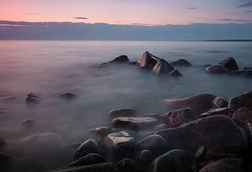 Roze meerlandschap met rotsblokken op het Baikalmeer in Rusland
