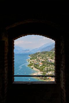 Uitzicht door een raam op het Gardameer bij Malcesine