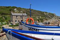 Brightly coloured fishing boats on dry land in the sun