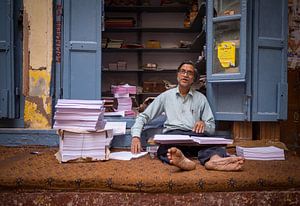 Mann vor seinem Kopierladen in Varanasi, Indien von Teun Janssen
