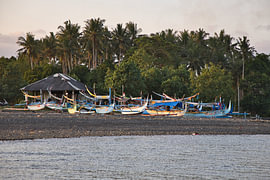 Colourful jukung fishing boats beneath palm trees, a haven in Medewi, Bali by Fotos by Jan Wehnert