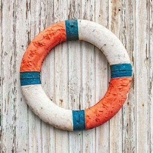 Oude reddingsboei op houten wand