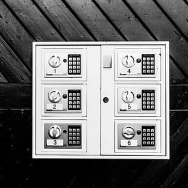 Black-and-white photograph of a door with door handle and lockers. by Wim Stolwerk